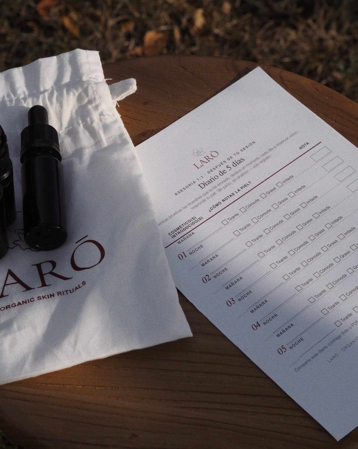Diario de 5 días de LARŌ junto a los sérums recomendados y la bolsa de tela de la marca